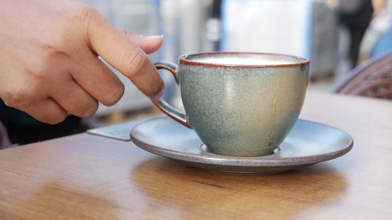 mano con una taza de café