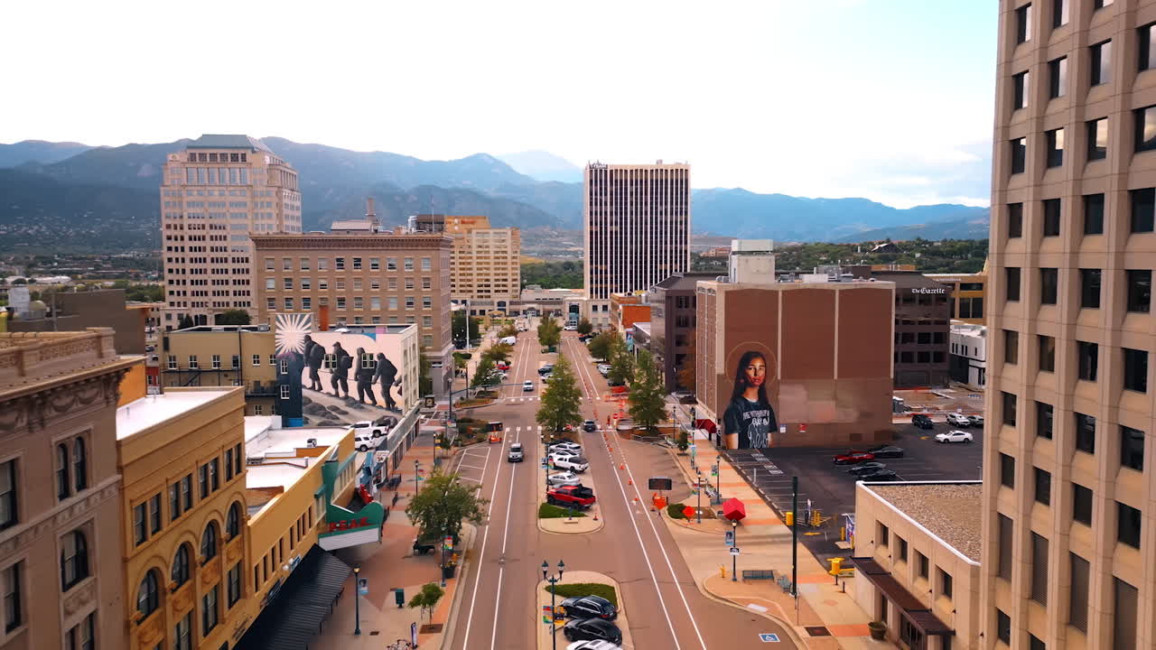 Colorado Springs, USA, 22 July 2025: Buildings with murals in the downtown of Colorado Springs, Colorado, USA. Drone footage above the wide street along the high-rises