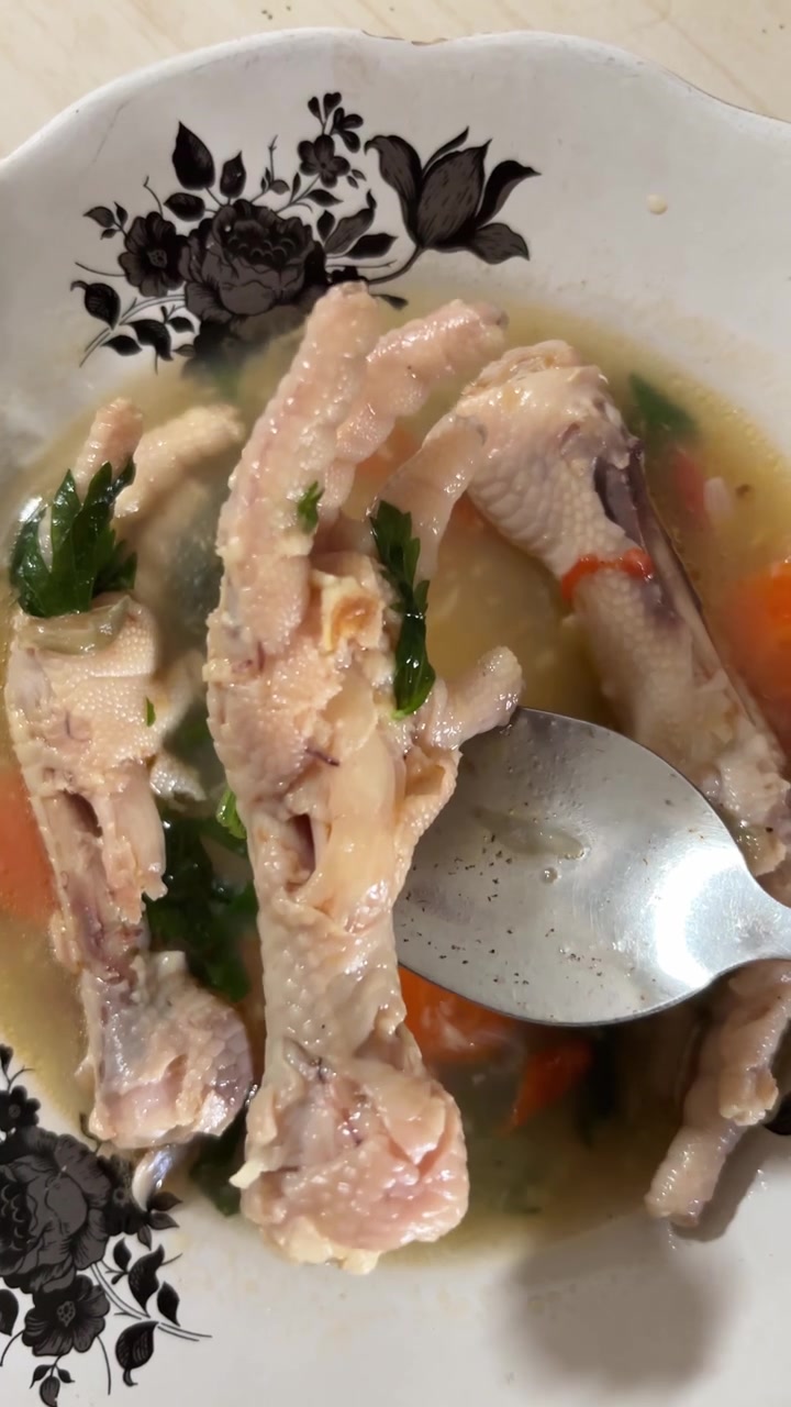ช้อนกำลังคนซุปตีนไก่ใส่ผักในชาม