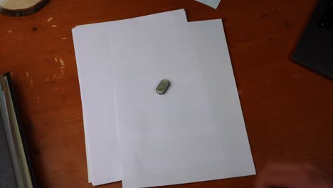 small-eraser-is-put-on-a-white-paper-and-taken-away-again