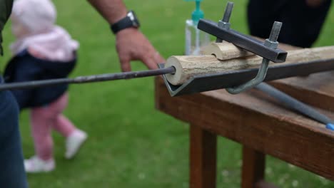 Traditional-Slovakian-music-instrument-Fujara-being-made-by-craving-and-drilling-in-wood,-traditional-village,-specialized-tools-being-used,-wooden-particles-flying-in-the-air