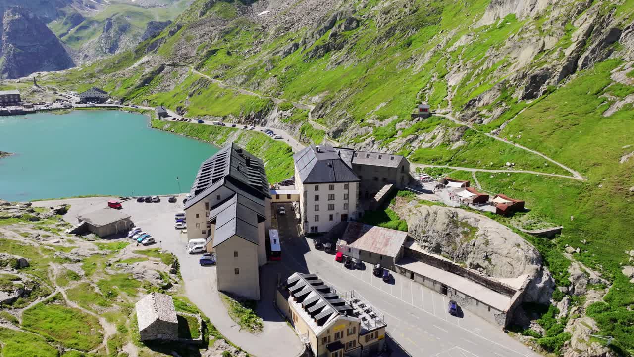Drone of turquoise alpine lake and border station at Col du Grand-Saint-Bernard