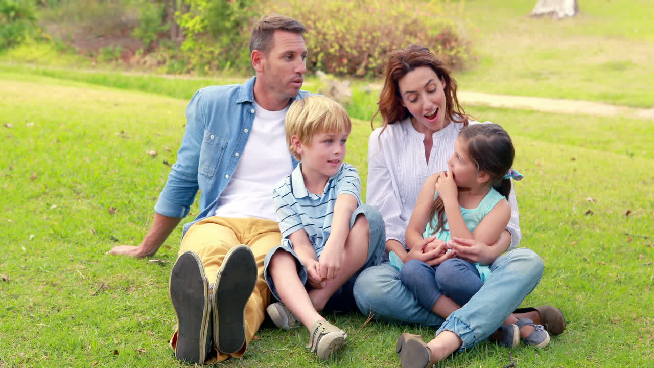 Happy family sitting on grass 