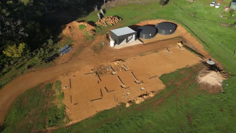 aerial orbit shot of foundation for farm building in rural area of australia at sunny day - construction site on countryside