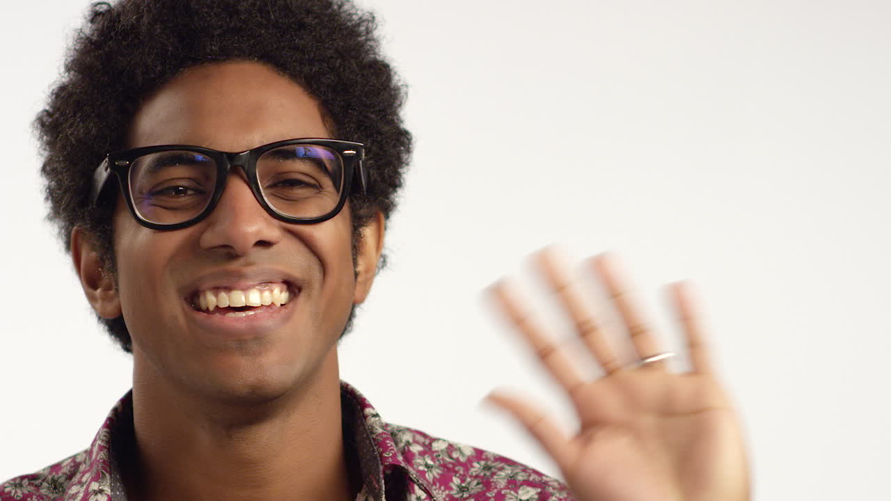 CU Man Smiles and Waves at Camera