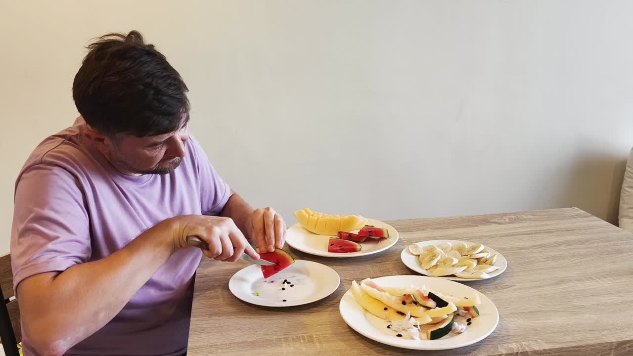 Man eating a variety of fruits