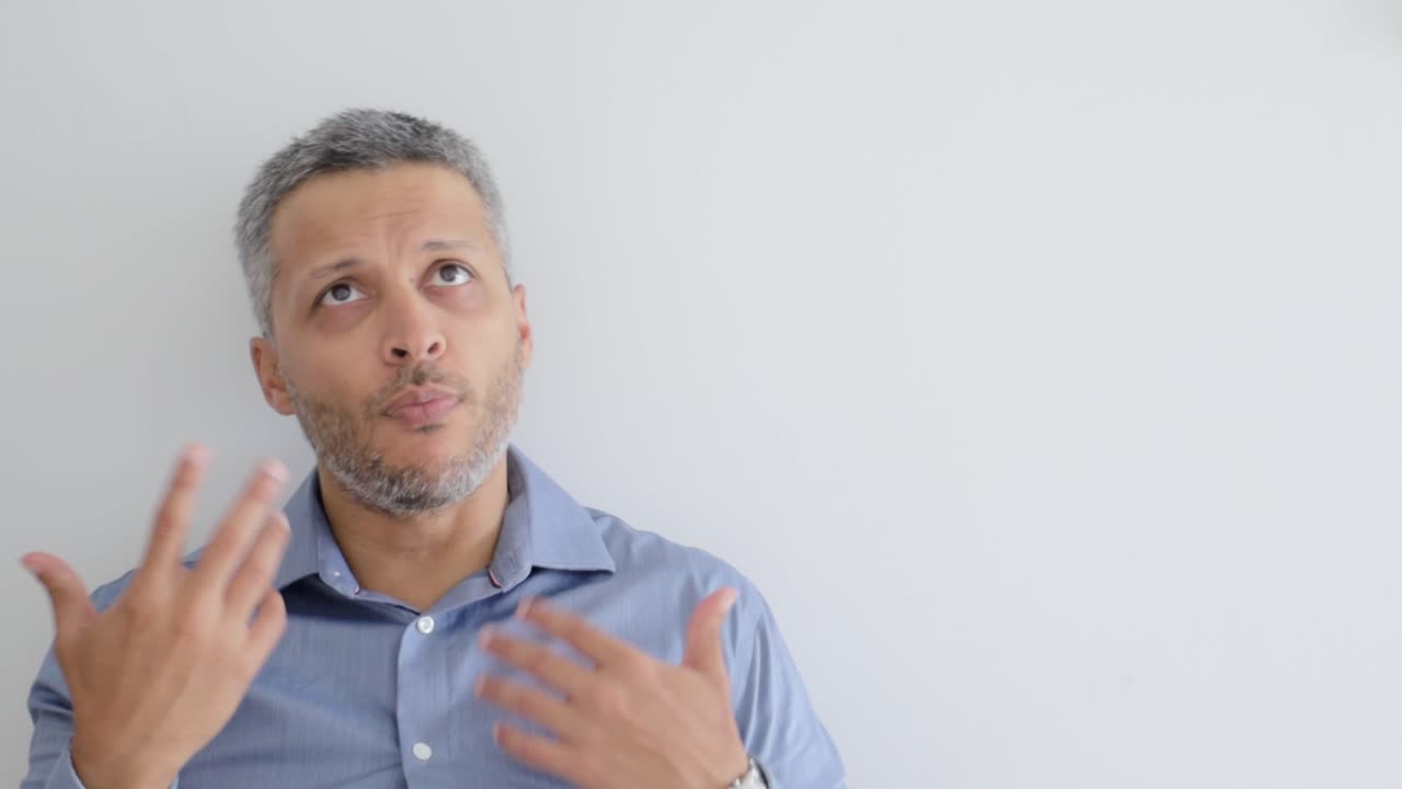 Man with Gray Hair Looking Up and Gesturing Expressively