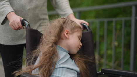 little girl with cerebral palsy sleeps in wheelchair at walk