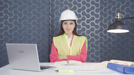 The-engineer-folds-her-arms-and-laughs-at-the-camera.