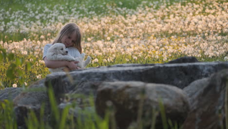 young girl lovingly rocking a puppy in her arms