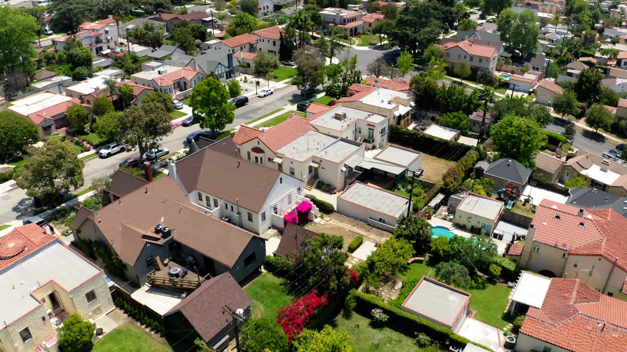 Aerial View of a Sunny Residential Neighborhood with Houses and Swimming Pools