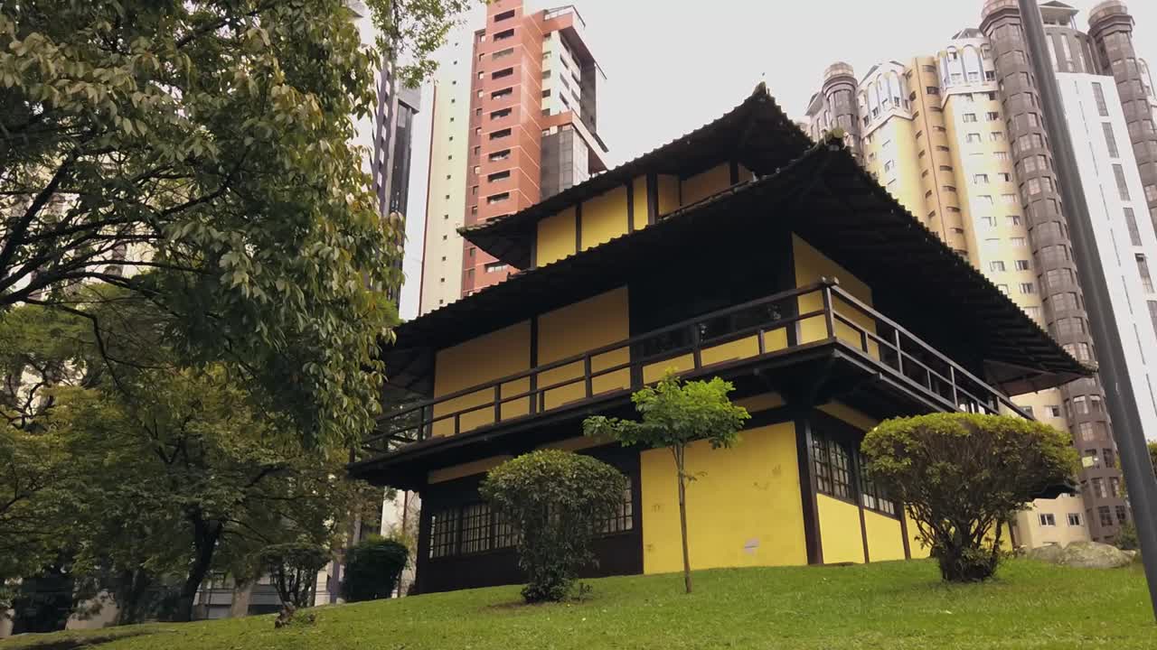 un templo tradicional japonés en medio de una ciudad exuberante, rodeado de muchos árboles en un entorno tranquilo y tranquilo, creando un lugar perfecto para relajarse