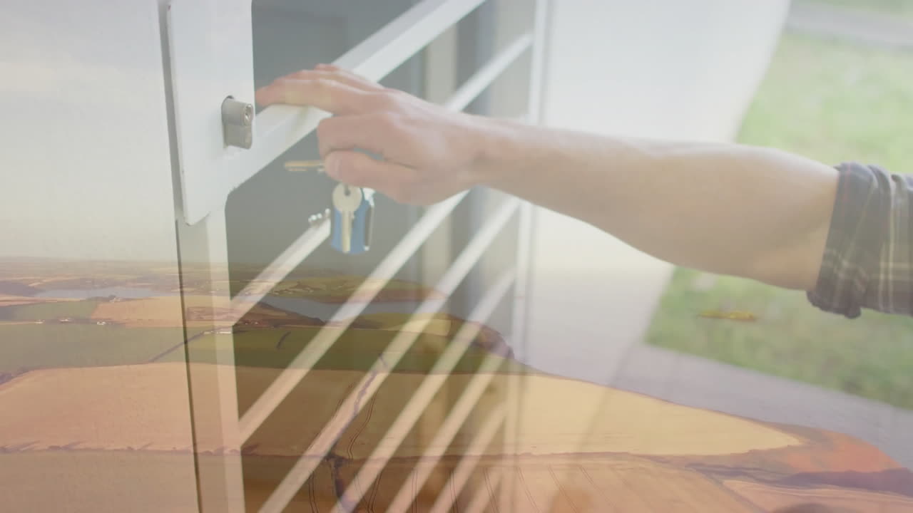 Turning key in lock with landscape view animation in background