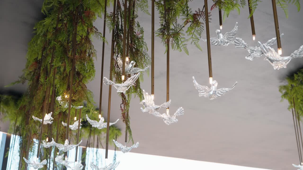 Crystal bird lights hanging with greenery at a luxurious event