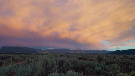 vast landscape with dramatic sunset clouds over mountains and sagebrush field