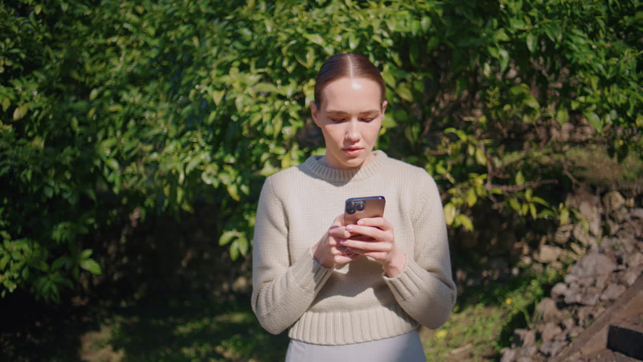 Focused girl chatting smartphone at park closeup. Young lady answering message