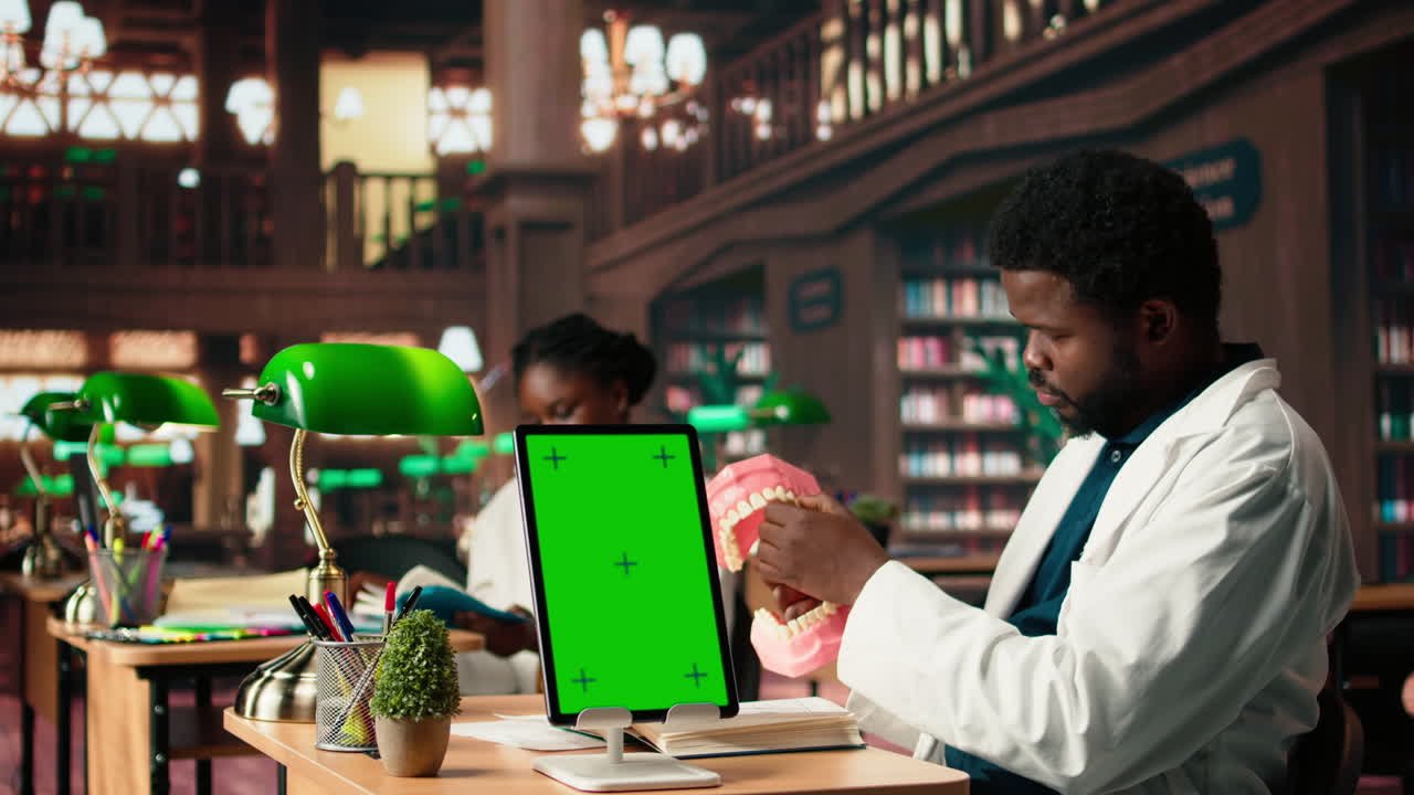 estudiante de medicina aprende prácticas dentales en un modelo de mandíbula simulada junto a la maqueta