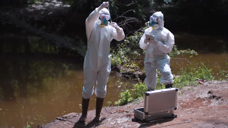 scientists in hazmat suits taking water samples