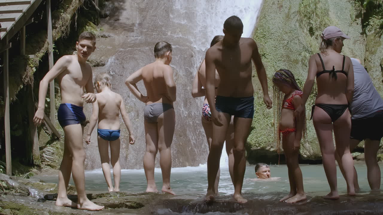 familia disfrutando de un baño en una cascada