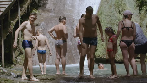 family enjoying a waterfall swim