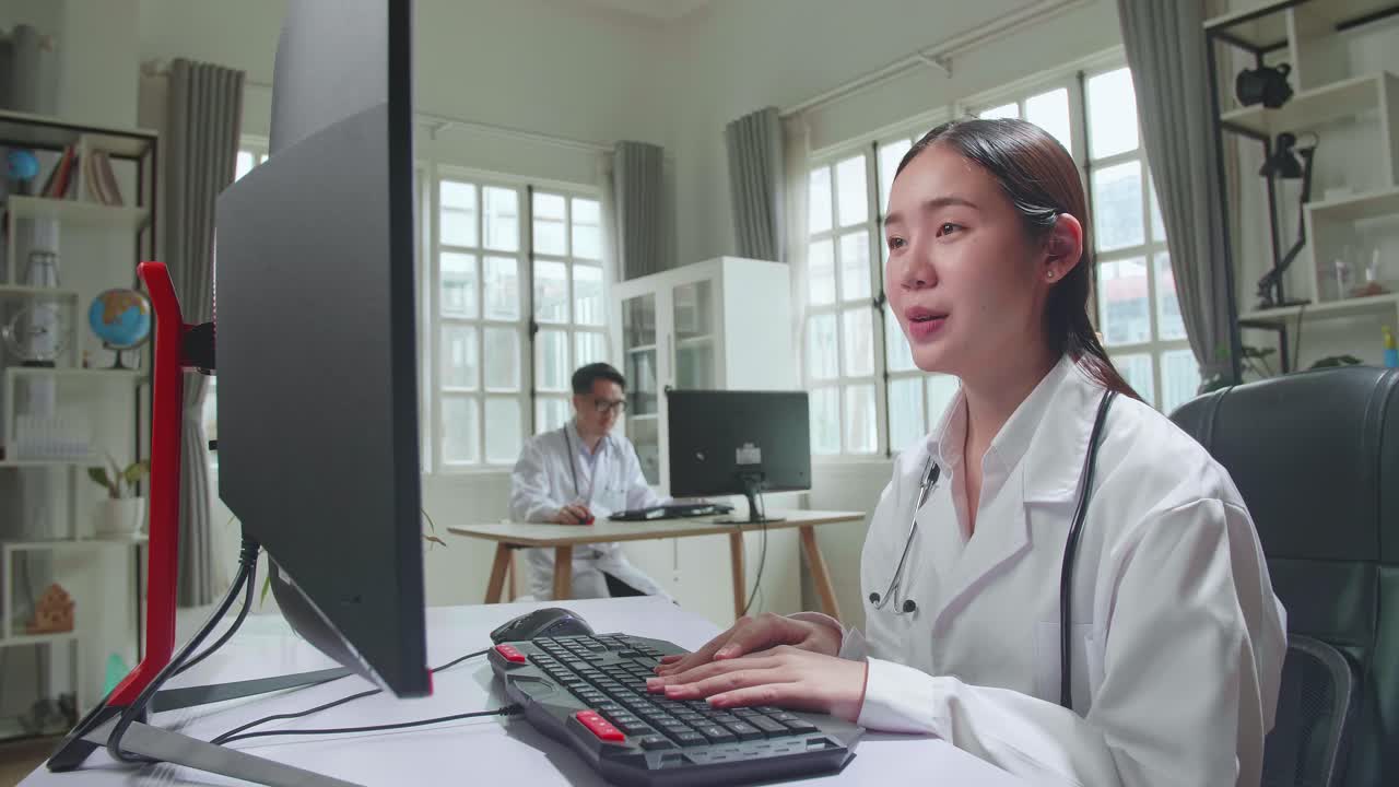 Asian Female Doctor Communicates With Patient By Video Link, Doctor Consults Patient Using Modern Technologies, Using Computer In Workplace