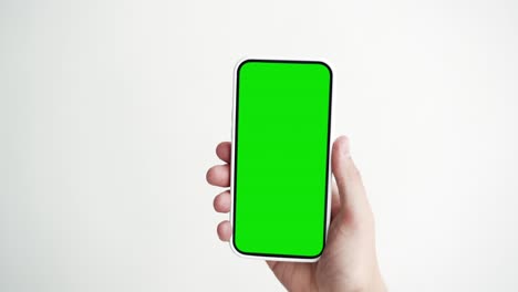 joven teléfono inteligente de pantalla táctil con tecla de croma verde de primer plano. chico tocando el gesto en el teléfono celular mock-up pov. concepto ver y mostrar internet redes sociales, llamadas, leer noticias, aplicación, iot, compras electrónicas