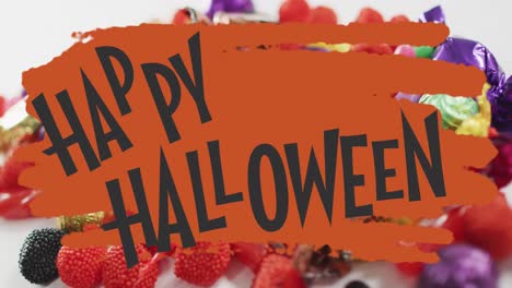 Happy-halloween-text-banner-with-flying-bats-icons-against-scary-eye-toy-and-halloween-candies