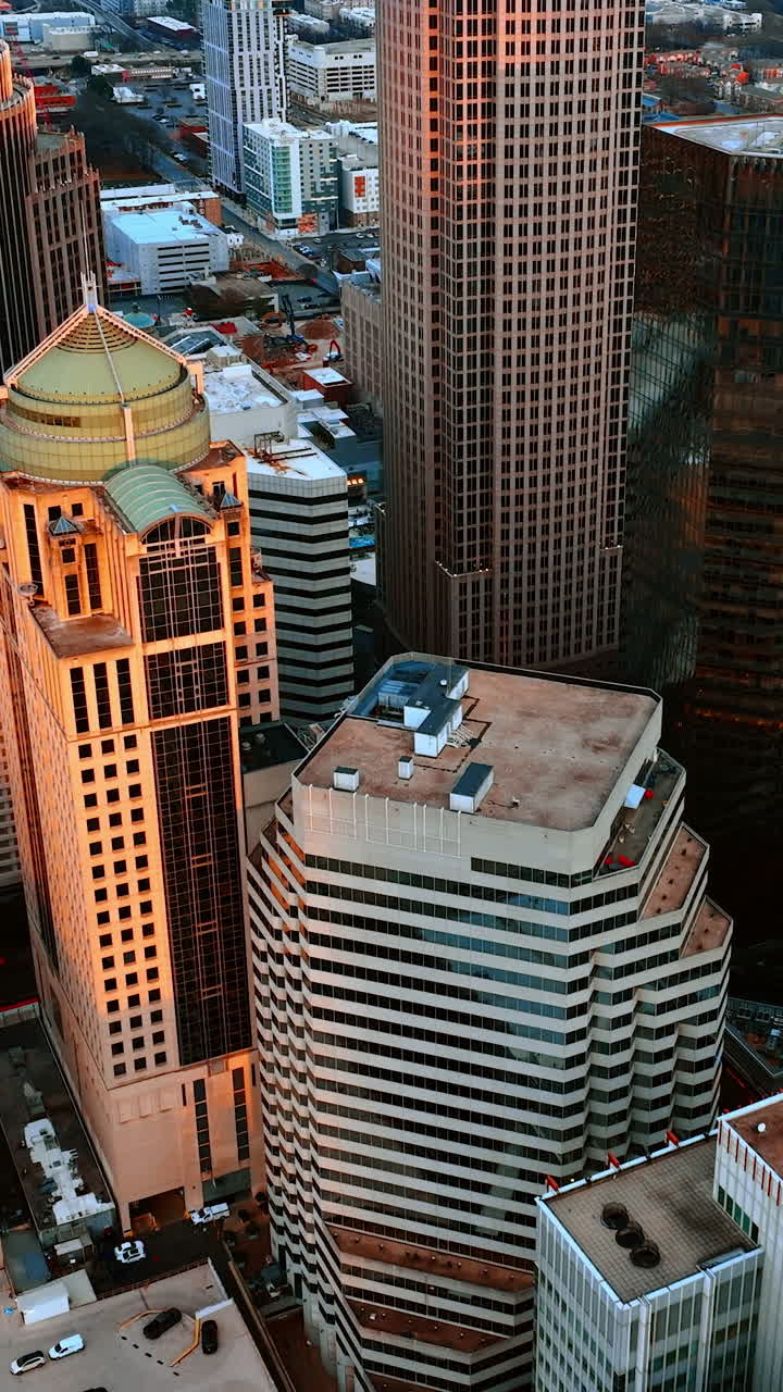 Centro città densamente costruito con edifici moderni di altezza e design diversi. Uptown di Charlotte, Carolina del Nord, USA dall'alto. Video verticale