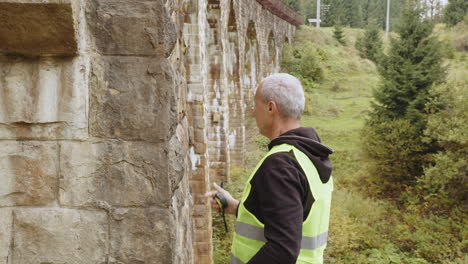 construction worker inspecting a stone bridge