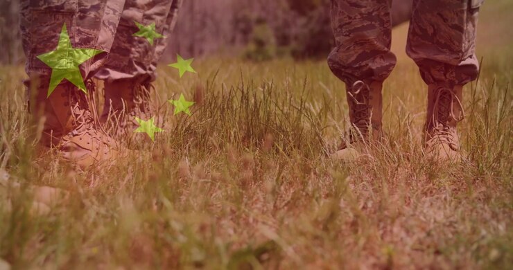 Soldati in movimento durante un'esercitazione di difesa, che si spostano sull'erba secca mentre stelle verdi fluttuano sopra gli stivali.