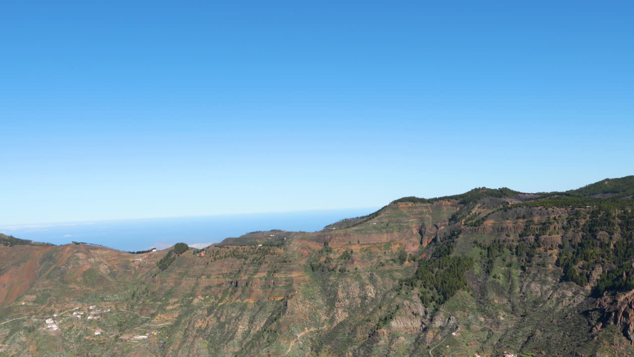 Rocce in un parco nazionale con molti alberi che si affacciano sull'orizzonte verso l'oceano, Isole Canarie, ripresa in slow motion 4K a 60fps