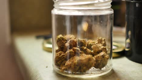 jar of cannabis buds is set on counter top