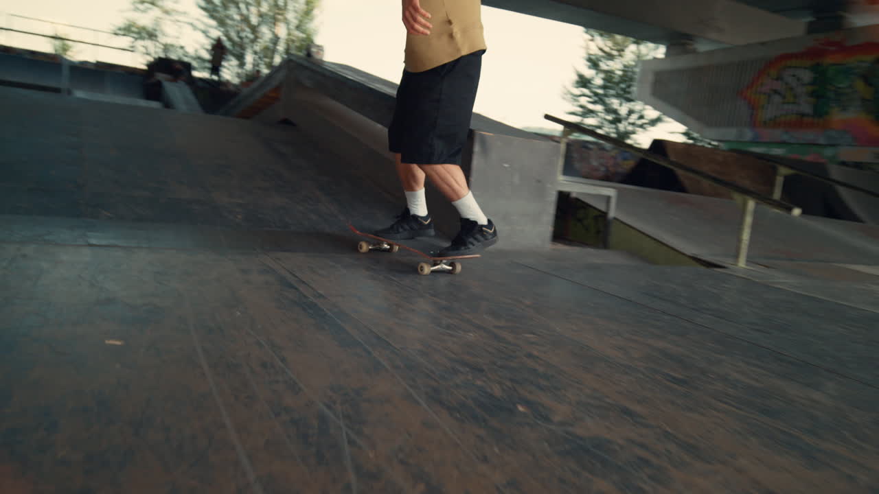 adolescente practicando salto de acrobacias en una tabla de skate en el parque de skate urbano.