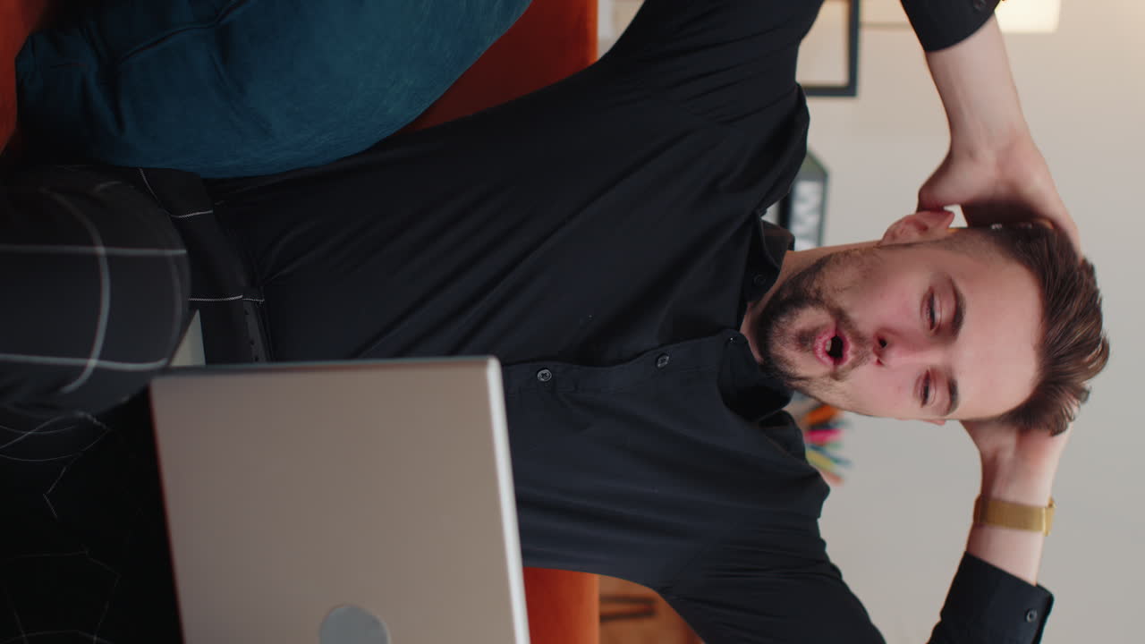 노트북으로 일하는 젊은이가 성공을 축하하고 복권에서 돈을 얻고 온라인에 좋은 소식을 얻습니다.