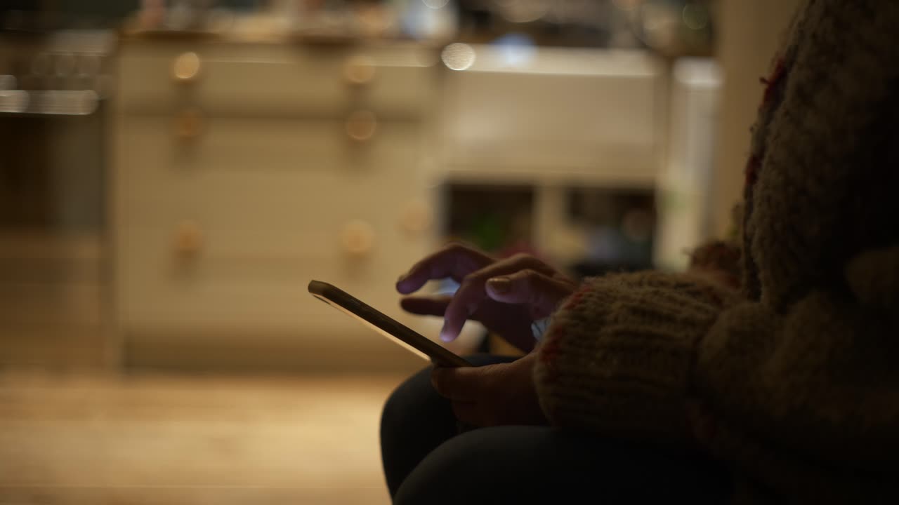 Kitchen interior, slider shot, close up of woman typing on phone in silhouette against bright kitchen