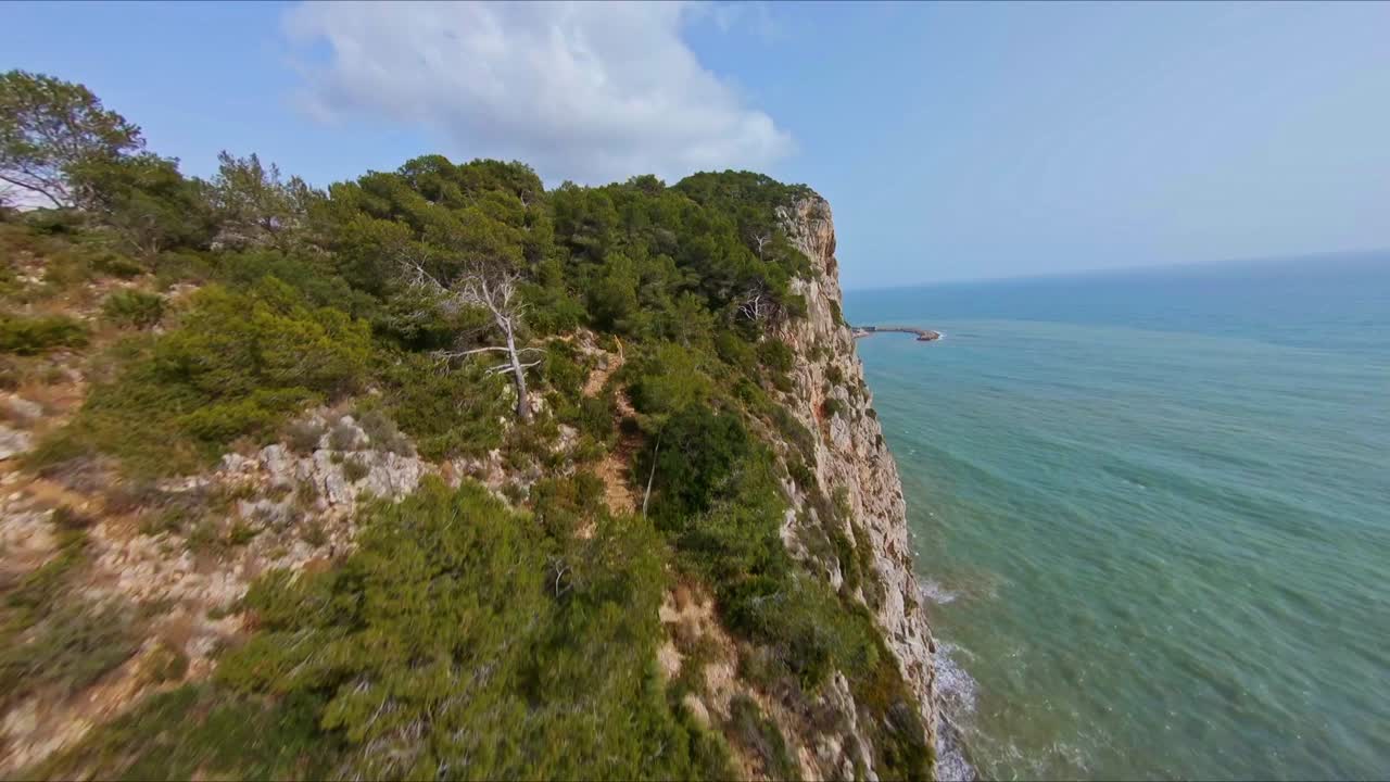 vista aérea volando a lo largo y abajo de los pintorescos acantilados costeros de garraf, españa