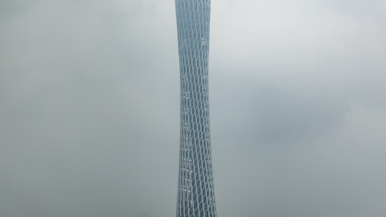 Alta torre moderna oscurata da nuvole in movimento e nebbia