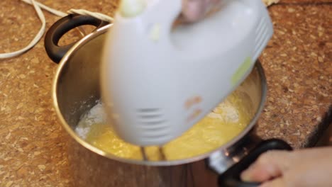 whisking egg and flour to prepare a boiled milk icing