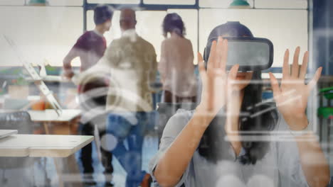 múltiples iconos digitales flotando contra una mujer de negocios que usa auriculares vr en la oficina