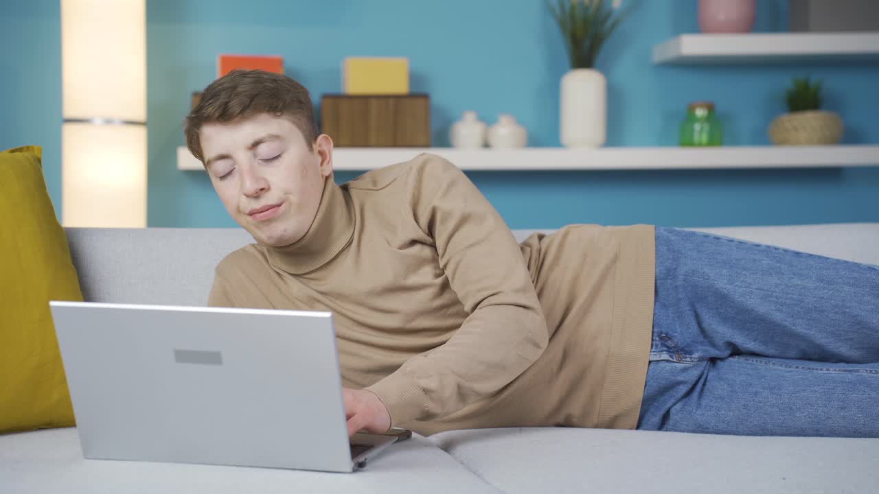 젊은 남자가 노트북으로 채팅하고, 지루하게 문자를 보내고 있습니다.