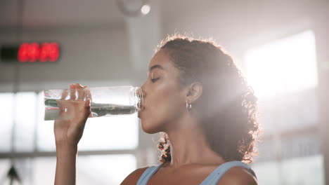 woman drinking water after workout