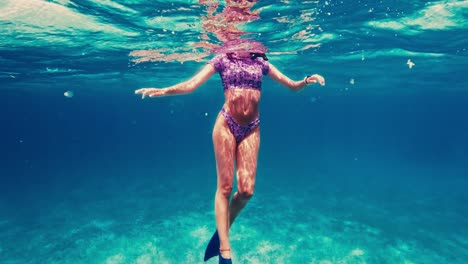 A-female-snorkeler's-body-underwater-treading-above-the-surface-in-Caye-Caulker,-Belize