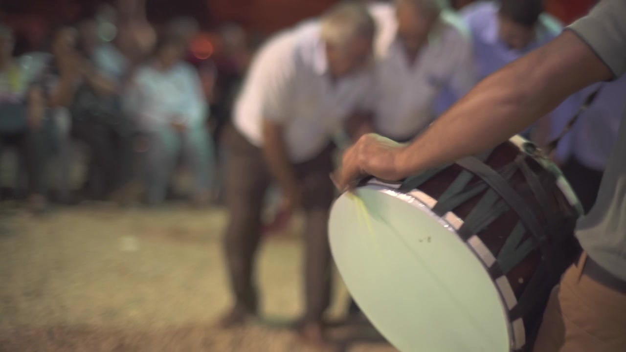 Musician Playing Traditional Drum at an Outdoor Cultural Celebration