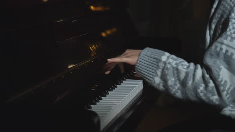 woman playing piano in a dark room