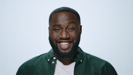 Portrait-of-happy-african-man-laughing-at-camera-on-light-background.