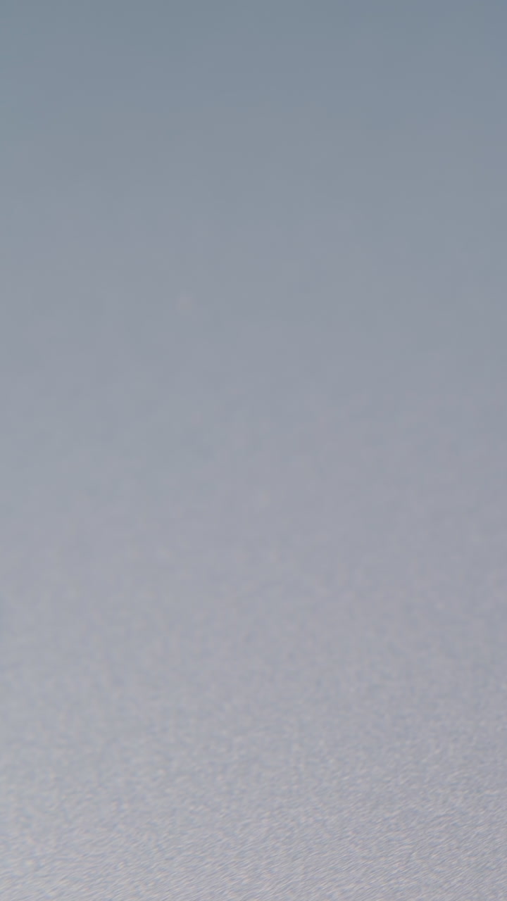 motion along small pile of new metal paperclips lying on clean grey background extreme close view