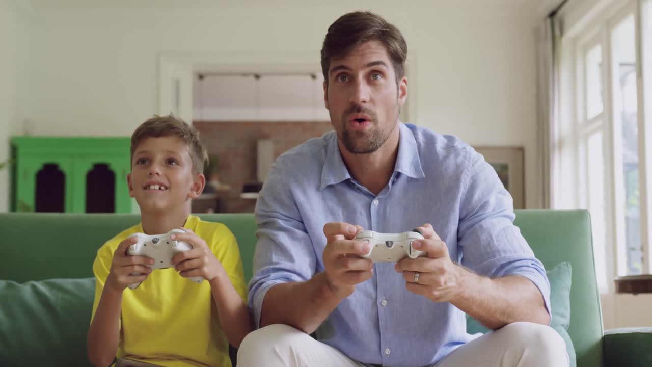 padre e hijo jugando videojuegos juntos en el sofá en casa 4k