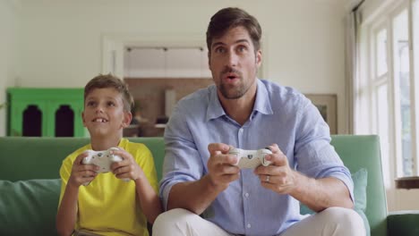 Padre-E-Hijo-Jugando-Videojuegos-Juntos-En-El-Sofá-De-Casa-4k