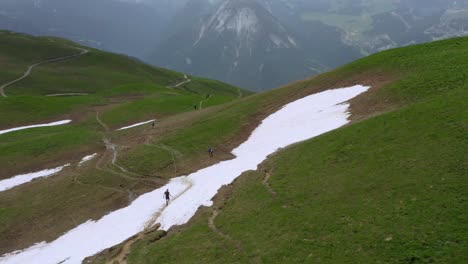 Toma-Aérea-Dando-Vueltas-Alrededor-De-Un-Grupo-De-Corredores-Caídos-En-Los-Alpes-Franceses-En-Un-Día-Nublado