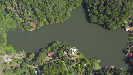 aerial shot overhead a small lake in the cerro azul countryside with cabins